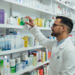 Pharmacist checking medications on shelf