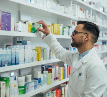 Pharmacist checking medications on shelf