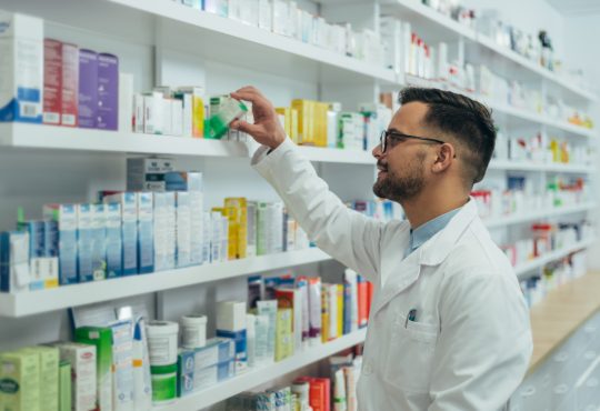 Pharmacist checking medications on shelf