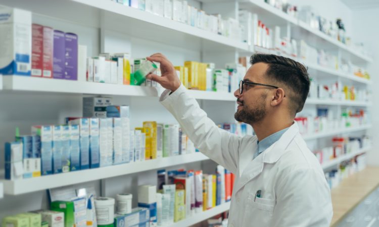 Pharmacist checking medications on shelf