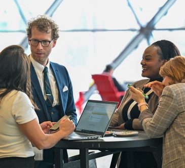 People gather around a high-top table at a conference