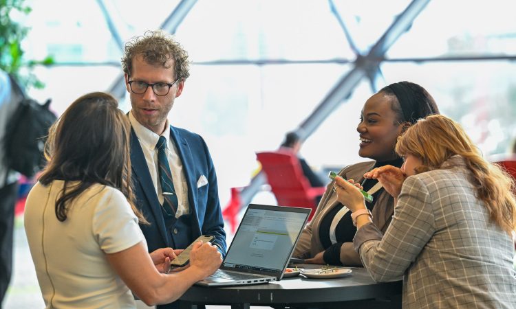 People gather around a high-top table at a conference