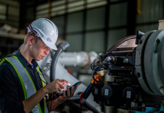 Technician checking for repair on factory machine