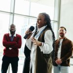 Confident woman speaking at a conference with colleagues in a modern office