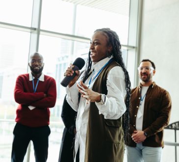 Confident woman speaking at a conference with colleagues in a modern office