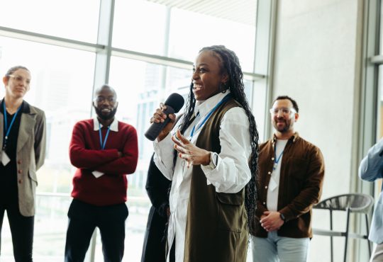 Confident woman speaking at a conference with colleagues in a modern office