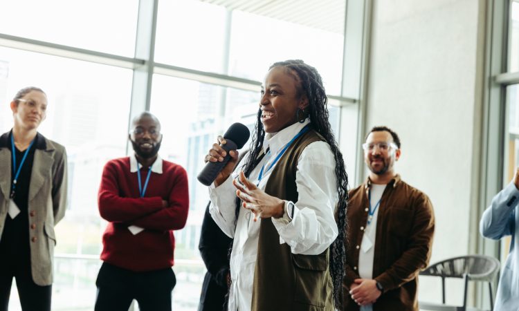 Confident woman speaking at a conference with colleagues in a modern office