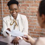 Woman smiling and holding resume during interview
