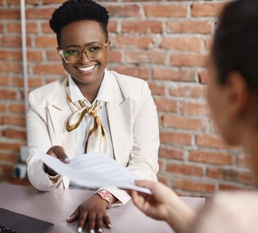 Woman smiling and holding resume during interview