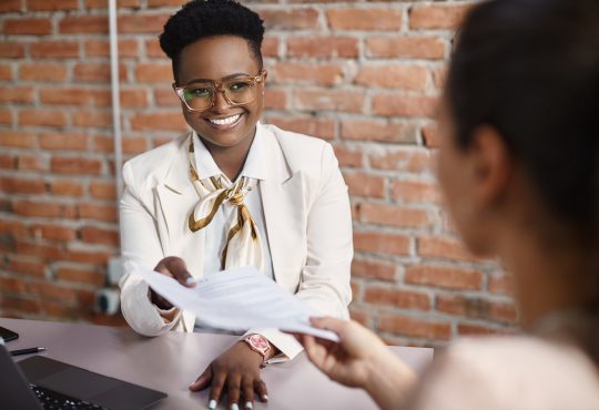 Woman smiling and holding resume during interview