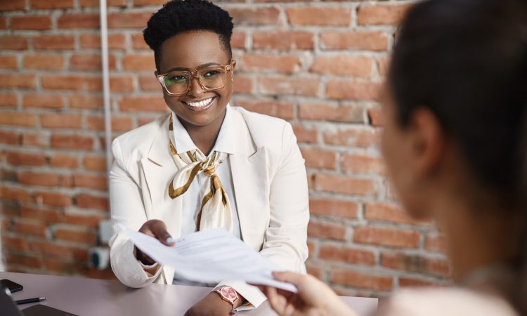 Woman smiling and holding resume during interview