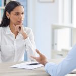 Mixed race hiring manger in interview with businessman.