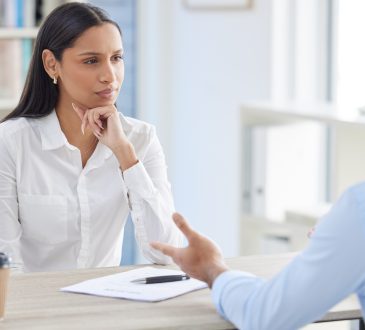 Mixed race hiring manger in interview with businessman.