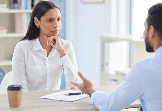 Mixed race hiring manger in interview with businessman.