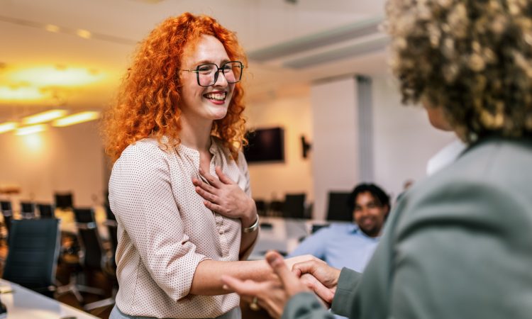 Two people shaking hands in office