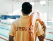 Lifeguard standing and facing pool