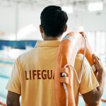 Lifeguard standing and facing pool