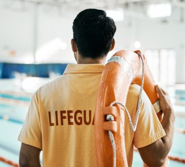 Lifeguard standing and facing pool