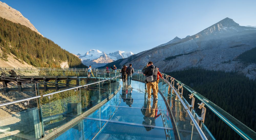 Tourists standing on glass-floored observation deck at Jasper National Park