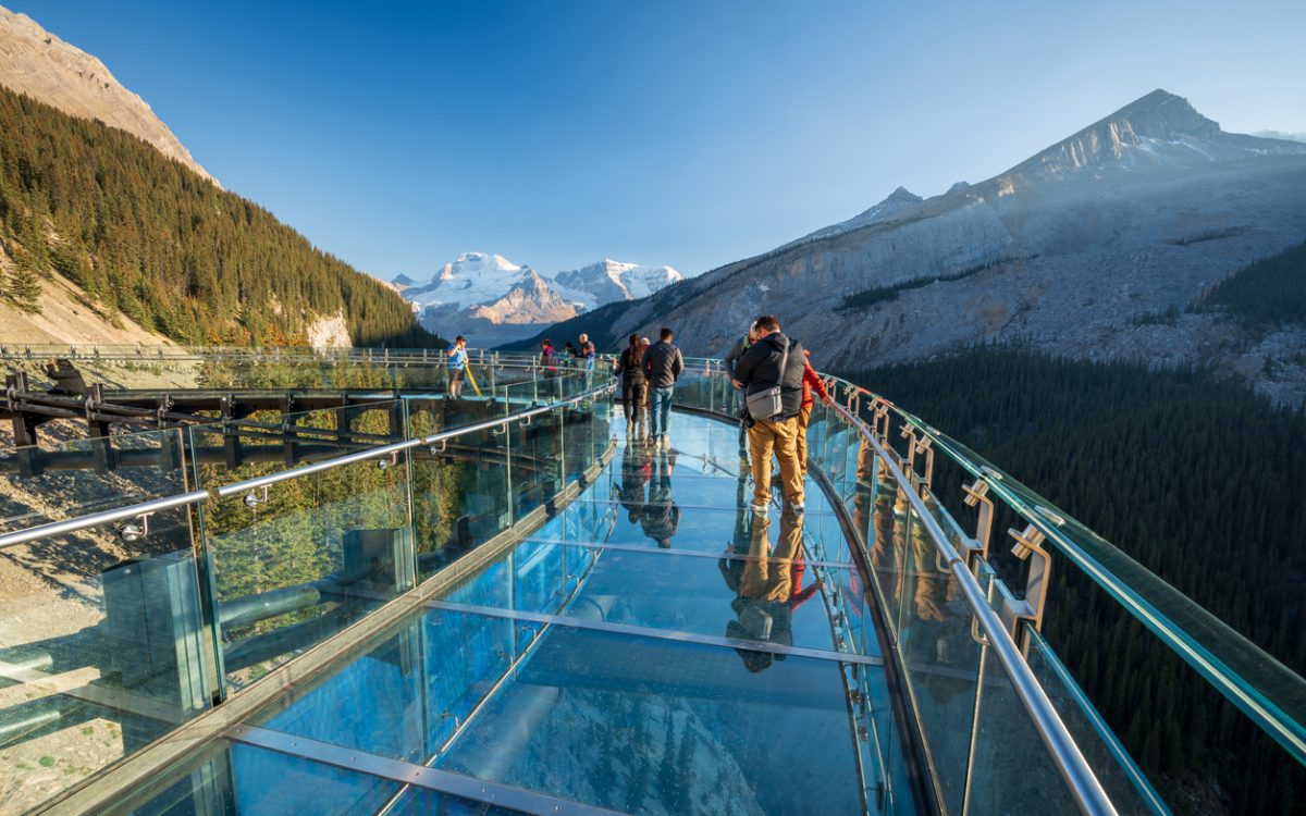 Tourists standing on glass-floored observation deck at Jasper National Park