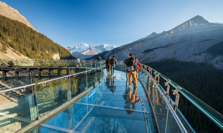 Tourists standing on glass-floored observation deck at Jasper National Park