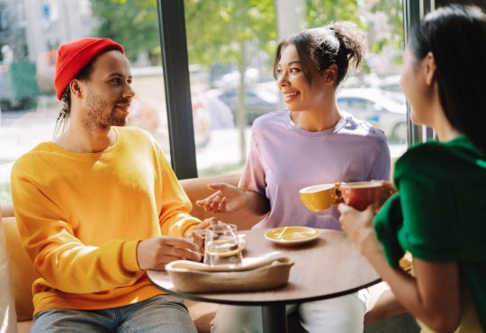 Three people talking in coffee shop