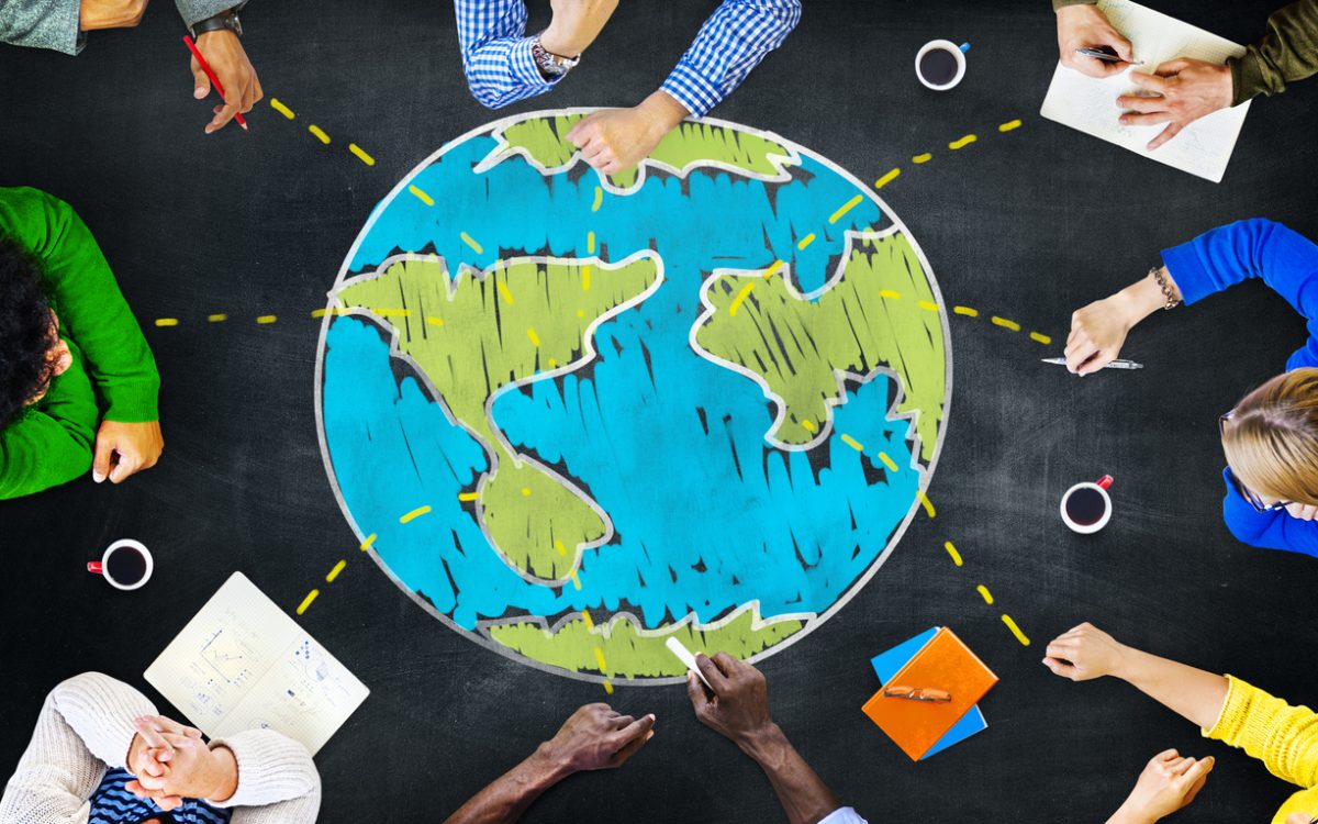 People sitting around drawing of globe