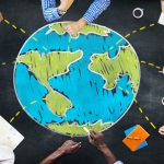 People sitting around drawing of globe