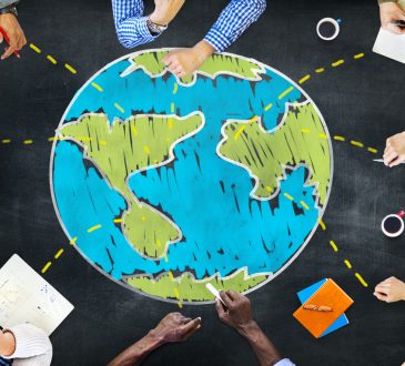 People sitting around drawing of globe