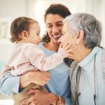 Grandmother, mother and baby in home playing