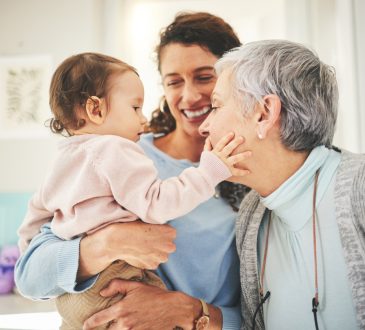 Grandmother, mother and baby in home playing