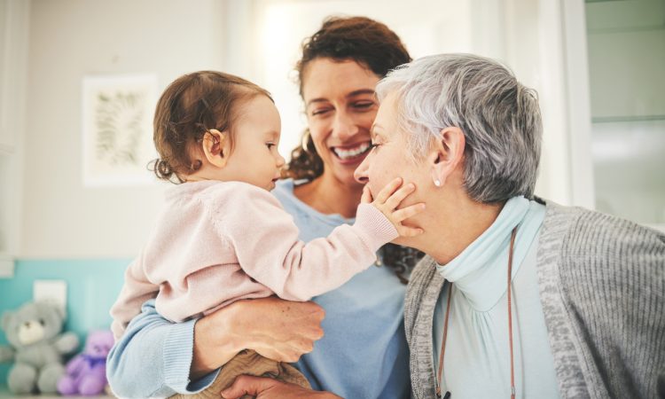 Grandmother, mother and baby in home playing