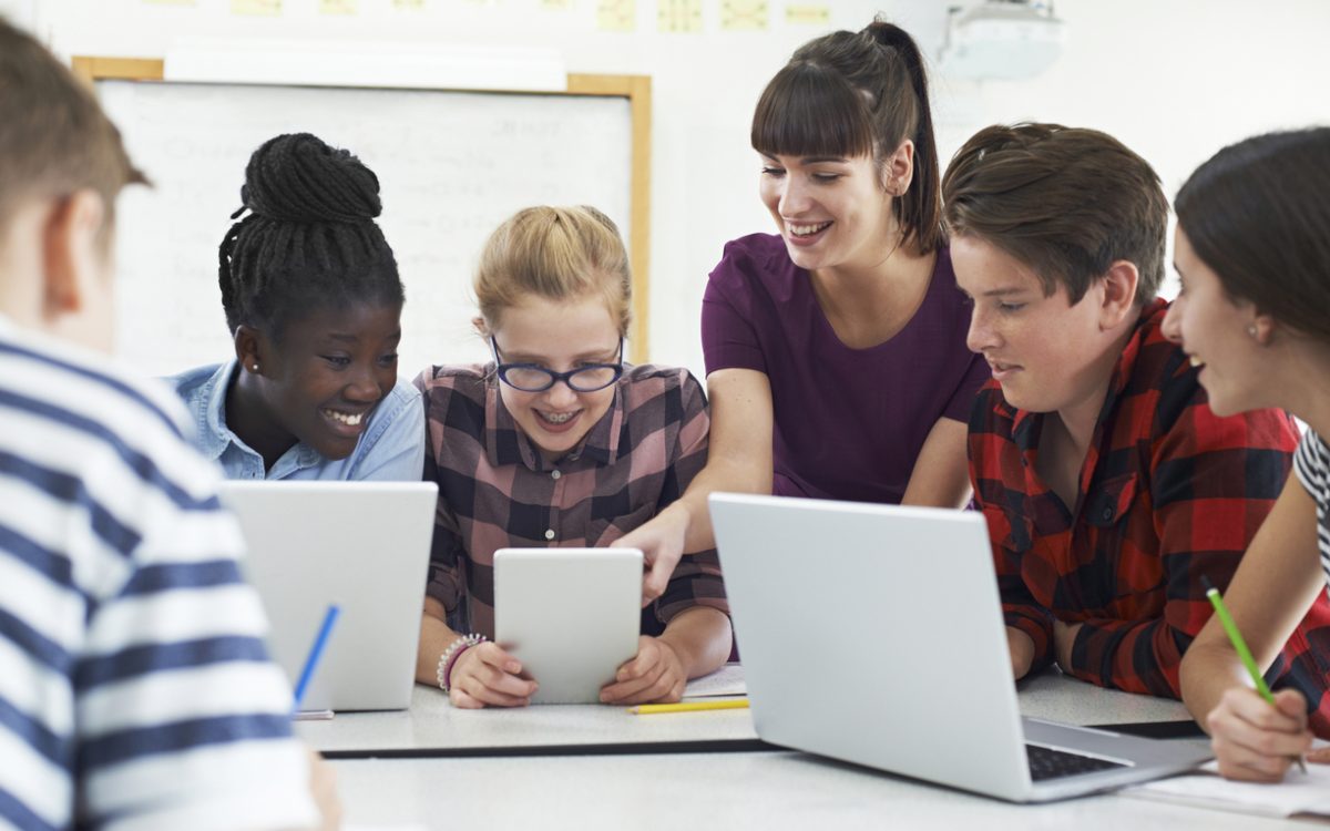 Teenage Students With Teacher In IT Class
