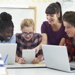 Teenage Students With Teacher In IT Class