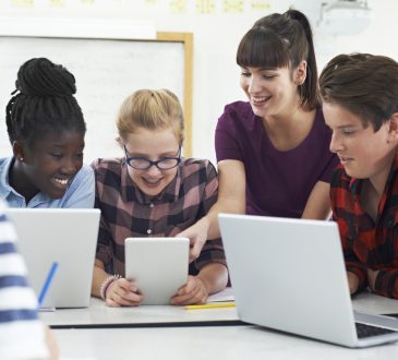 Teenage Students With Teacher In IT Class