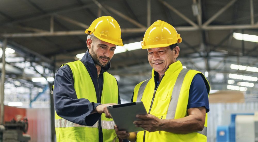 two engineers look projects and planning with tablet mobile in factory