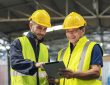 two engineers look projects and planning with tablet mobile in factory