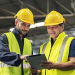 two engineers look projects and planning with tablet mobile in factory