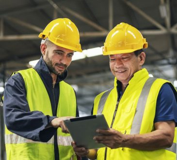 two engineers look projects and planning with tablet mobile in factory