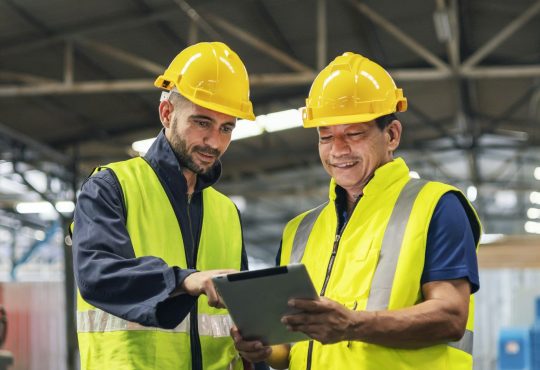 two engineers look projects and planning with tablet mobile in factory