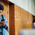 Teen texting in hallway of school