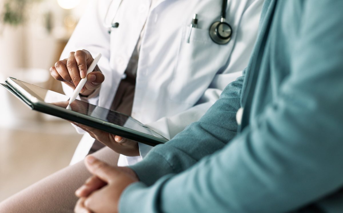 Closeup of hands of doctor looking at tablet