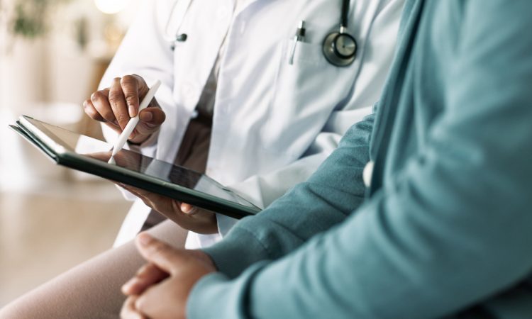 Closeup of hands of doctor looking at tablet