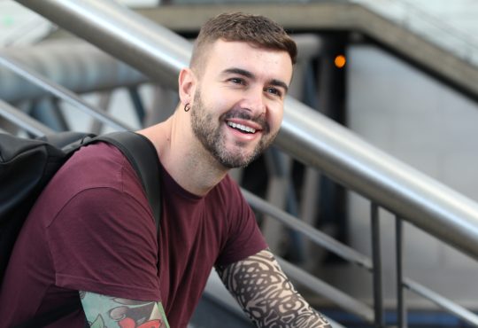 Young man sitting on stairs smiling