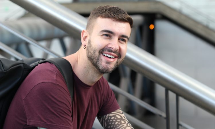 Young man sitting on stairs smiling