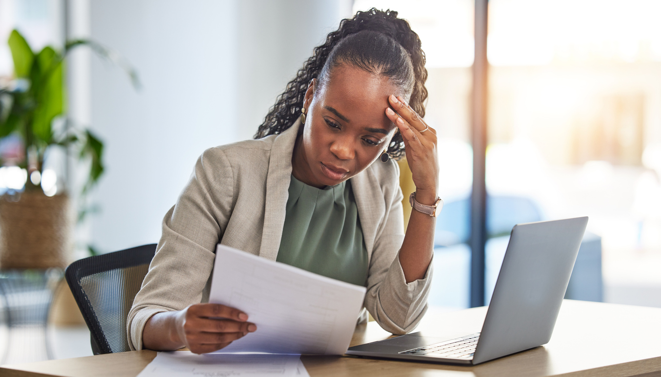 Stressed woman in office looking at papers