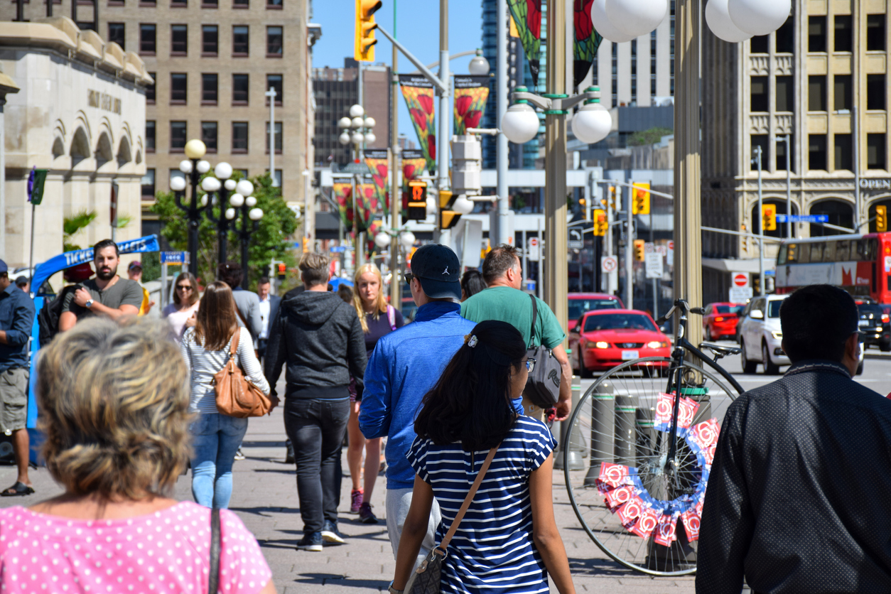 Crowd of people walking on busy Wellington street in downtown Ottawa