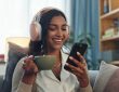 Woman listening on headphones while drinking tea