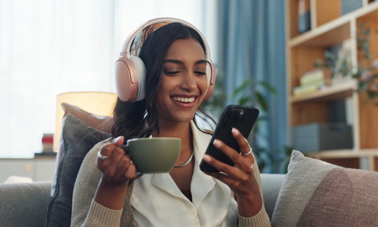 Woman listening on headphones while drinking tea