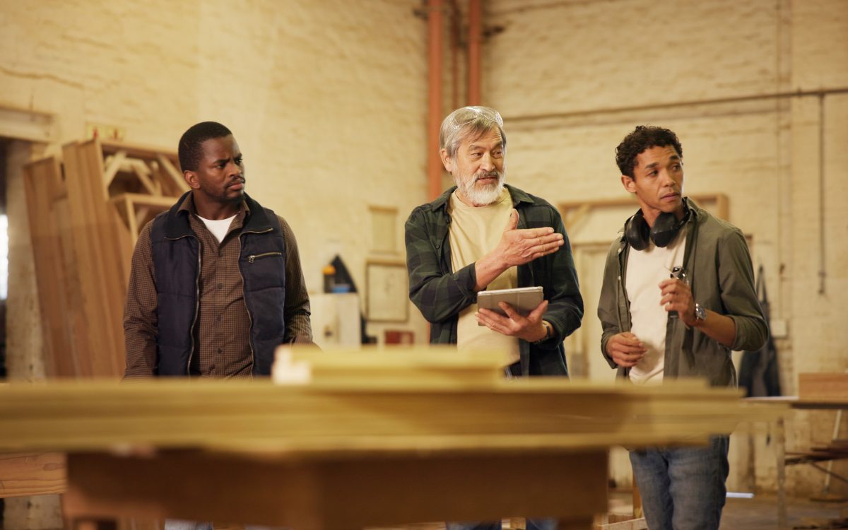 Workshop, men and group with tablet, carpenter or discussion with research, woodworking or technique. People, mature mentor and review of info